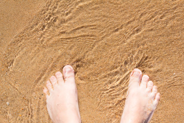 Feet on sand and sea. Summer mood.
