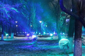 light show, a mysterious New Year lighting illumination. The lighting in the form of cosmic spheres. The photo was taken at slow shutter speeds. Snow, winter, Christmas. Close-up, copy space.Planets