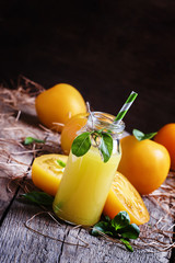 Freshly squeezed juice of yellow tomatoes with basil in a glass