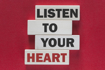 Obraz premium Listen to your heart. Motivational message written on wooden tiles
