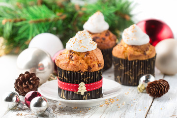 Festive Christmas cupcake decorated with whipped cream on white wooden rustic background. 