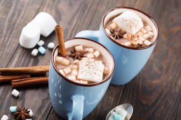 Blaue Tassen heißes Schokoladengetränk mit Marshmallows und Zimt auf dunklem Holzhintergrund. Winterzeit. Urlaubskonzept, Selektiver Fokus