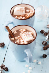Cups of hot Chocolate drink with Marshmallows, blue wooden table, Winter time