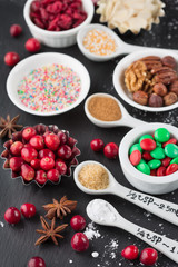 Christmas baking cupcake decorations and sprinkles, black background, selective focus. Holiday concept, winter time