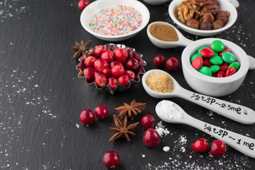 Christmas baking cupcake decorations and sprinkles, black background, selective focus. Holiday concept