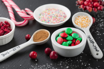 Christmas baking cupcake decorations and sprinkles, black background. Holiday concept