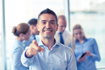 group of smiling businesspeople meeting in office