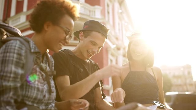 Travelers giving highfive smiling looking at map outside Slow motion