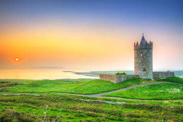Prachtig Iers kasteel in de buurt van de Atlantische Oceaan bij zonsondergang, Co. Clare