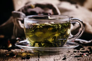 Crédence de cuisine en verre imprimé Theé Cup of green tea with flower petals and fruits, vintage wooden b