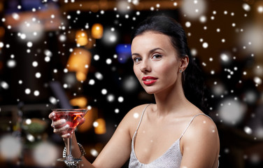 glamorous woman with cocktail at night club or bar