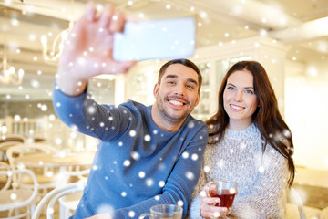 couple taking smartphone selfie at cafe restaurant