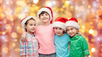 Obraz premium happy little children in santa hats hugging