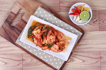 Fried spicy basil with shrimp and side dish as halve green lemon ,red chili and garlic are popular Thai food. 
