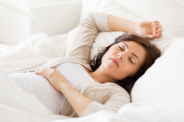 happy pregnant woman sleeping in bed at home