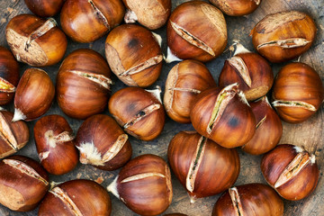 Roasted sweet chestnuts in clay rustic plate. Top view