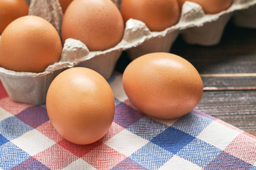 Chicken eggs and pulp egg carton on table