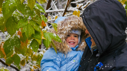 Fototapeta na wymiar guy and child plays with a snowy tree branch