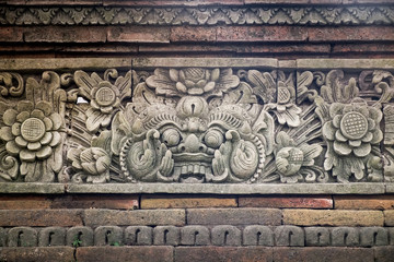Close up view of carved stone fence of traditional Hindu temple with demon guard in Indonesia, Bali.