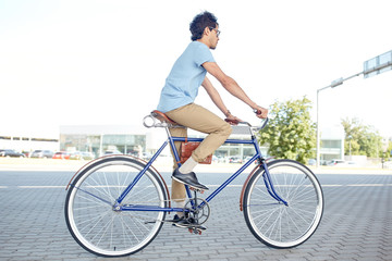 Naklejka premium young hipster man riding fixed gear bike