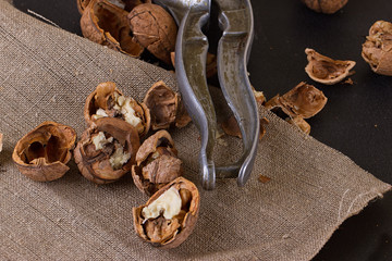 walnuts and nutcracker on table covered with burlap