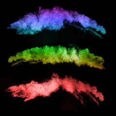 Explosion of colored powders on black background