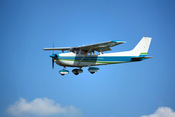 Light general aviation aircraft on final with cloud sky landing configuration