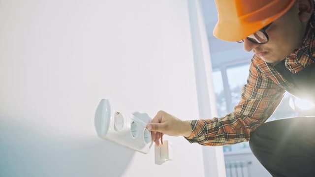 Electrician testing the current to a wall plug