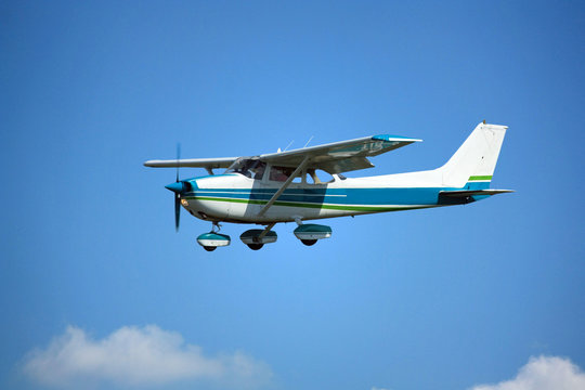 Fototapeta Light general aviation aircraft on final with cloud sky landing configuration