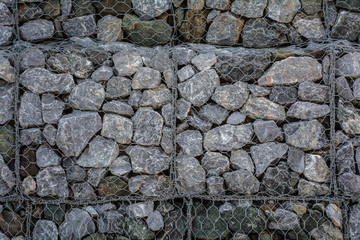 Stone walls in net  prevent soil and stone slides at Kung Wiman, Chanthaburi, Thailand. background.
