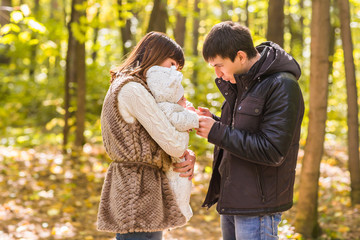 Fototapeta premium love, parenthood, family, season and people concept - smiling couple with newborn baby in autumn park