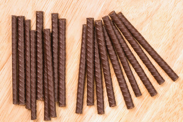 chocolate sticks lie on a wooden surface abreast. chocolate dessert. neatly folded sweetness