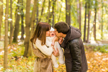 Young couple with newborn son outdoors in autumn