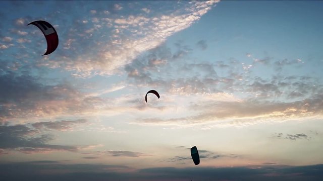 Four kites for kitesurfing flying at background of a sky with setting sun. HD