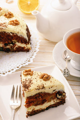 Piece of carrot cake with cheese cream on white background.