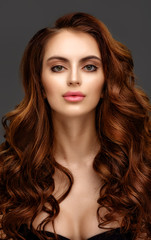 Fototapeta premium Portrait of a beautiful young woman with elegant long red shiny hair