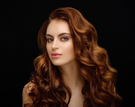 Portrait of a beautiful young woman with elegant long red shiny hair