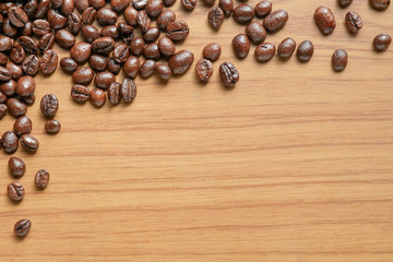 Roasted coffee beans/ View of coffee beans on wood background with copy space. Top view.