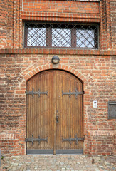 Solid wooden door on brick Gothic church, Poland