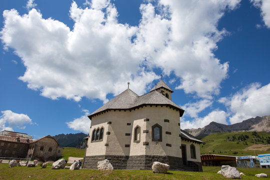 Beautiful mountain church under a sunny blue sky with clouds/Trentino/Dolomites/Italy