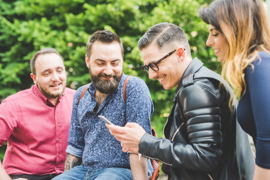 Group Of Friends Looking At Message On Cellphone