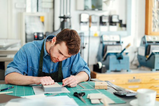 Young man working at table in printing shop