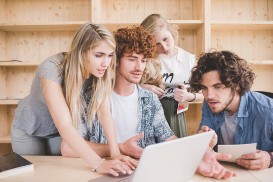 Co-workers working on laptop in office