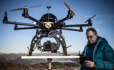 Mature man preparing to fly drone, Stresa, Piedmont, Italy
