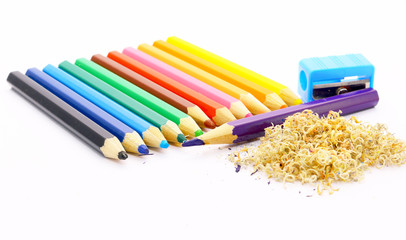 colorful pencils and pencil shavings on white background