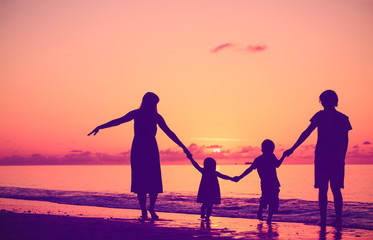 happy family with two kids walking at sunset