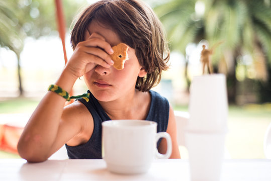 Boy looking through hole in biscuit