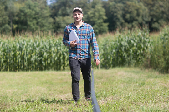Farmer in field carrying paperwork