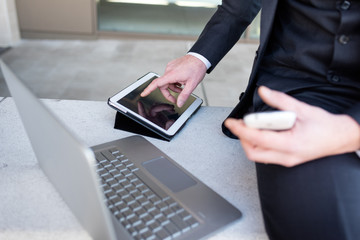 Close up on the hand of multitasking businessman using tablet, computer and smart phone - technology, social network, business concept