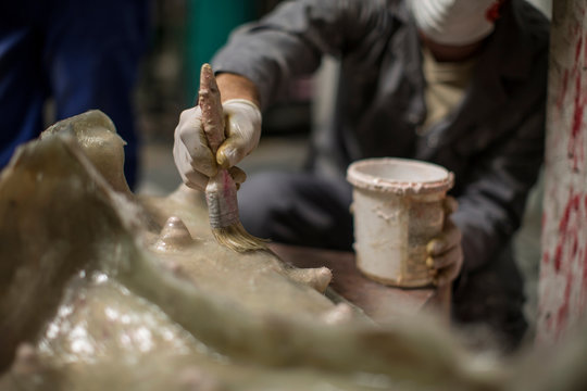 Sculptor in artists' studio creating sculpture